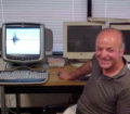 Evangelos Yfantis smiles amidst a collection of computers