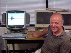Evangelos Yfantis smiles amidst a collection of computers