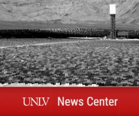 Black and white photo of a solar farm in a desert valley.